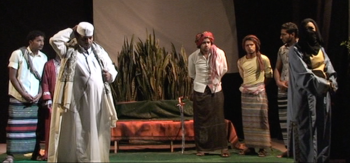 Courtroom scene from the 2013 Yemeni adaptation of The Merchant of Venice. Foreground: the judge, perplexed, in white; Fitna [Portia] in disguise in blue and yellow. Photo by Wagdi Al-Maqtari, courtesy of YALI/Akram Mubarak.